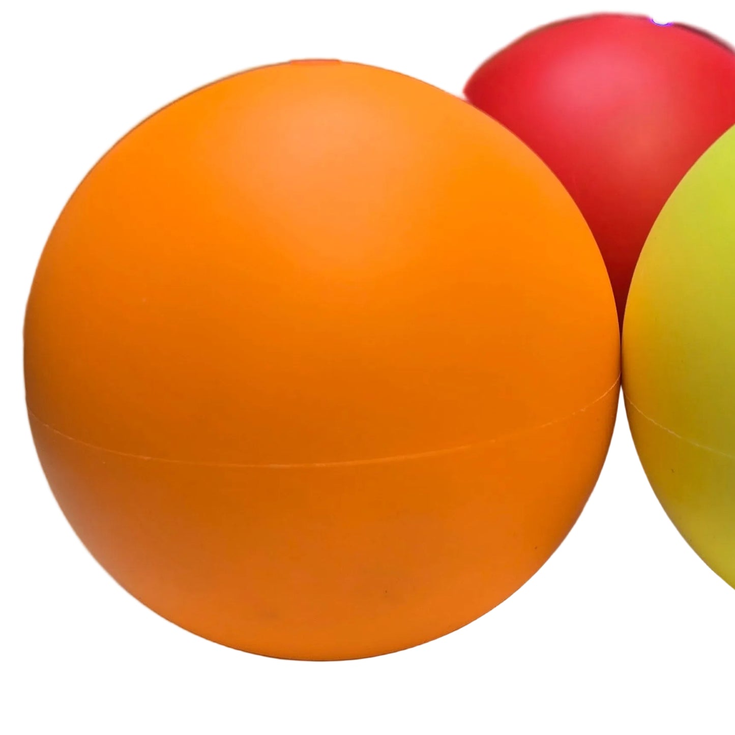 Three MMX Plus Juggling Balls by Play in red, orange, and yellow sitting on a blank surface