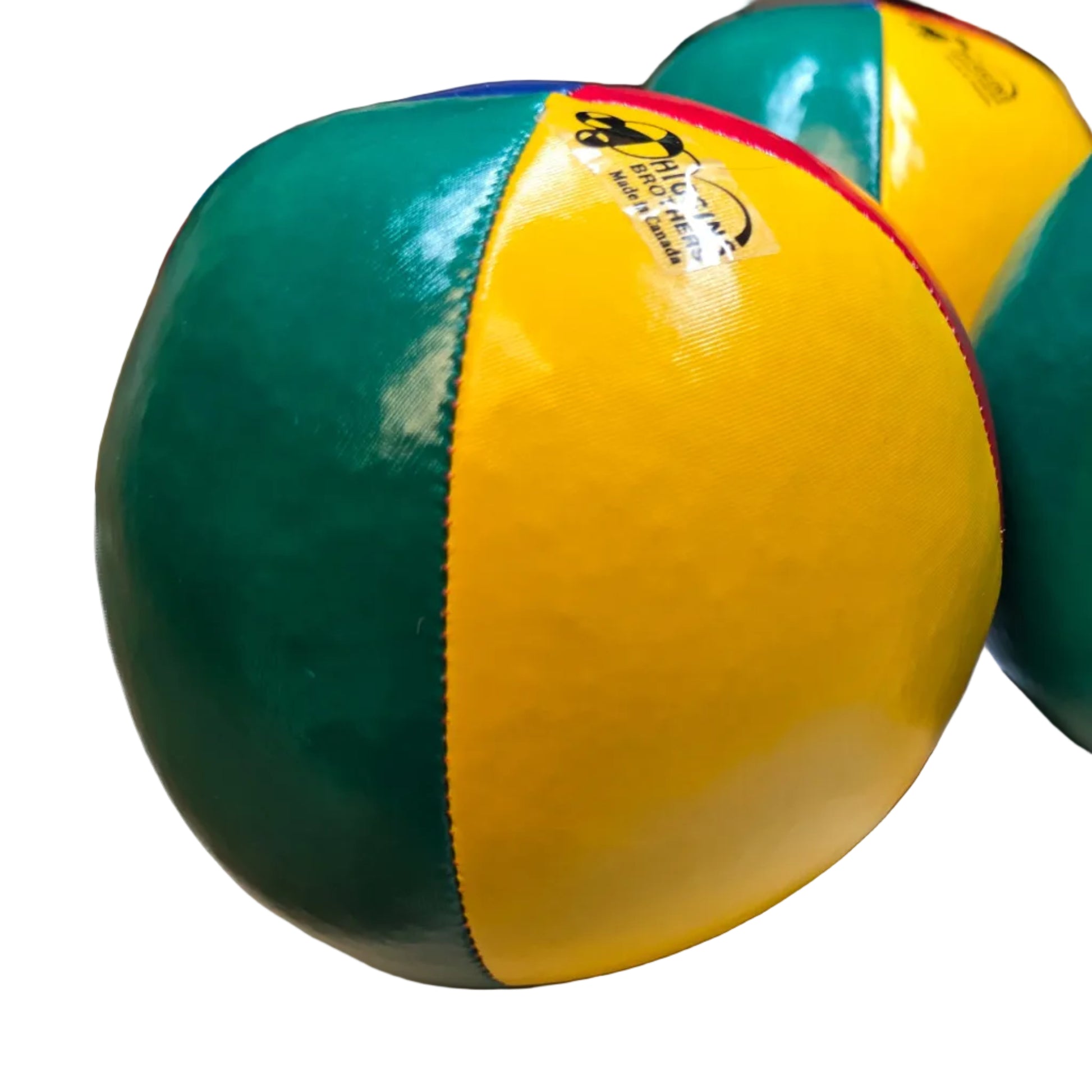 Three colorful juggling balls on a white surface with a blurred background.