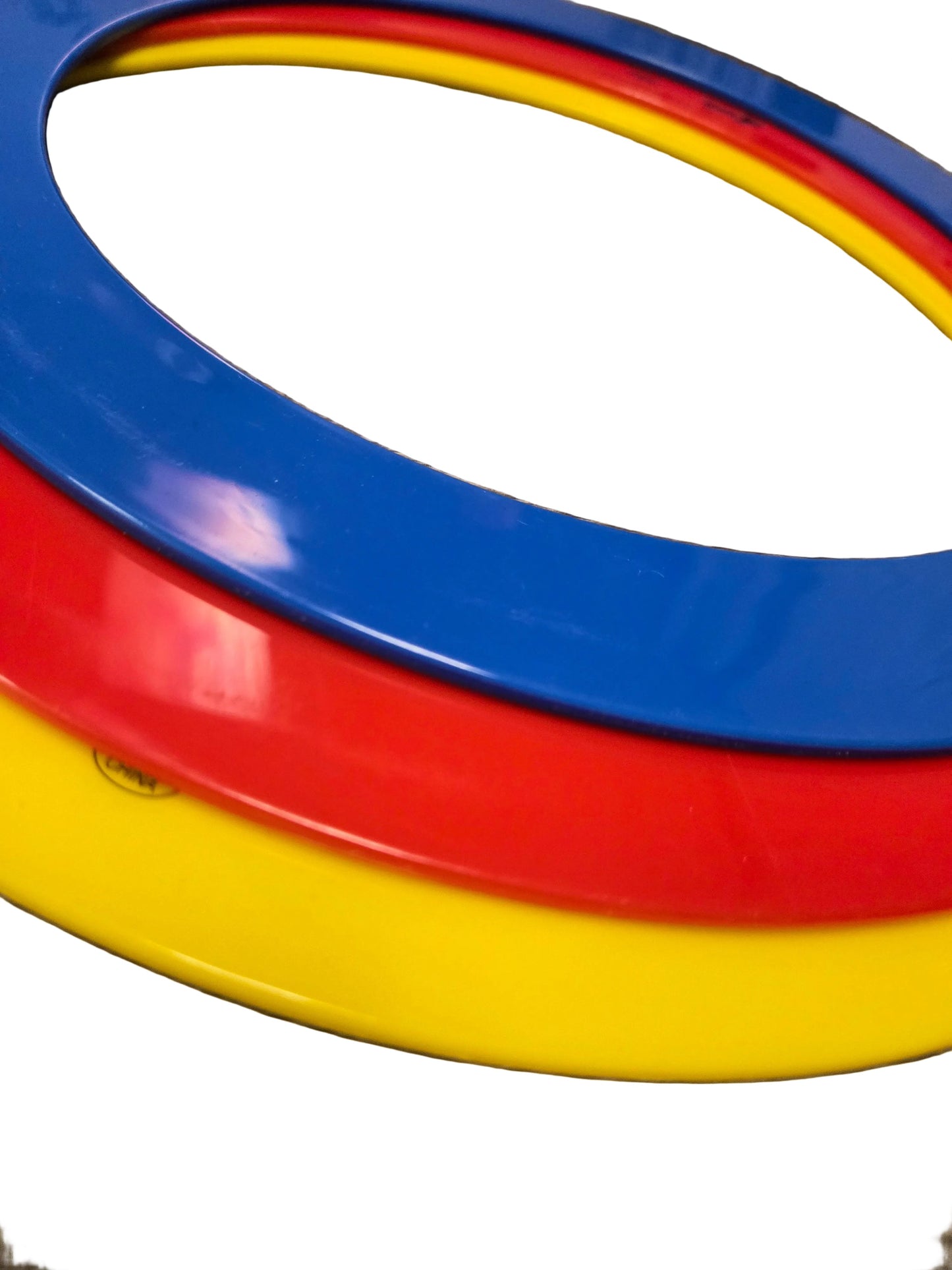 Three colorful rings (blue, red, yellow) stacked on a white surface