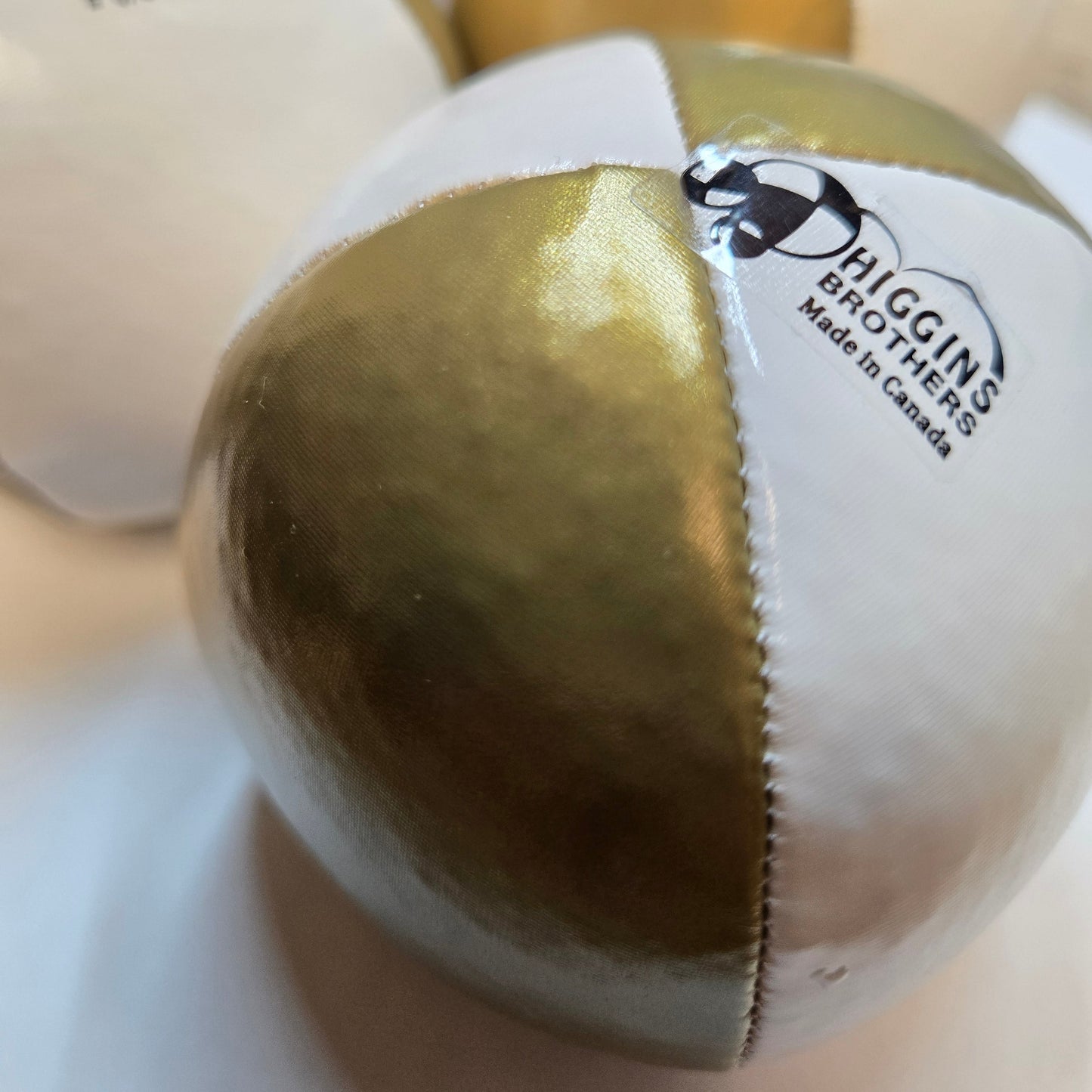 closeup of higging bros performer ball in gold and white. 