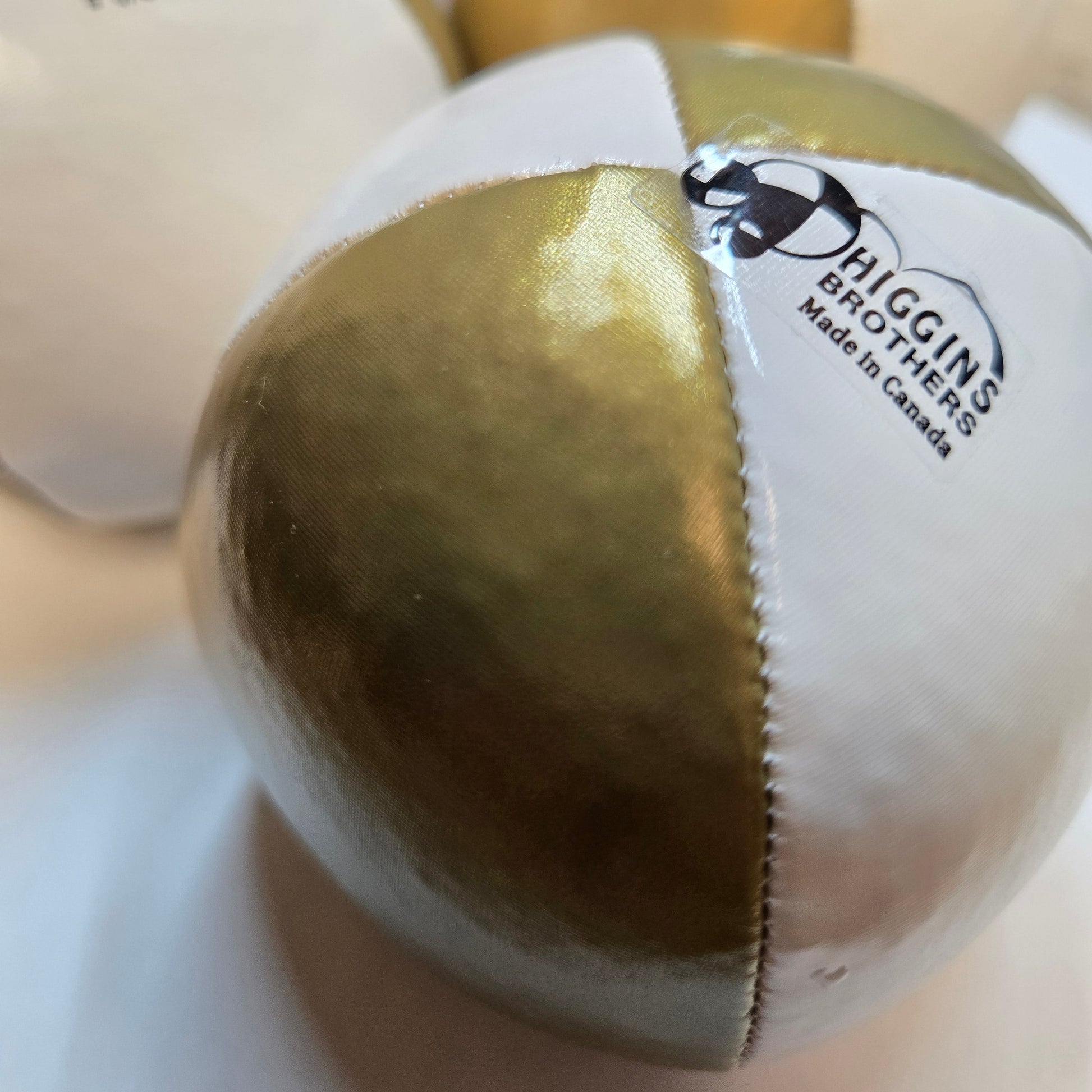 closeup of higging bros performer ball in gold and white. 